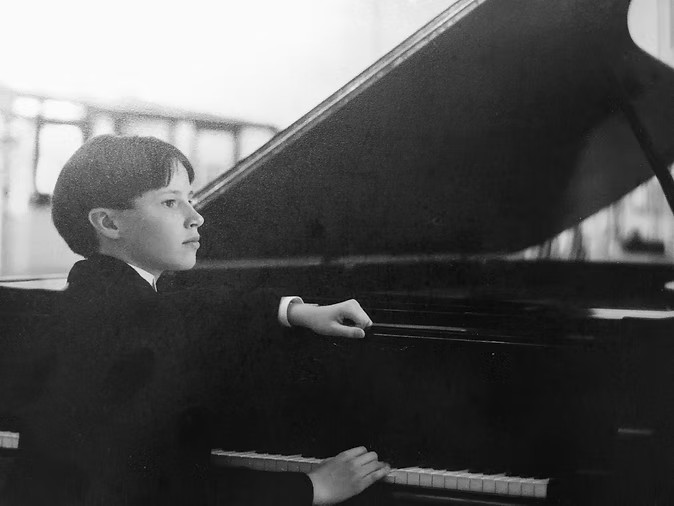 Young Eric Greenwood performing at the piano